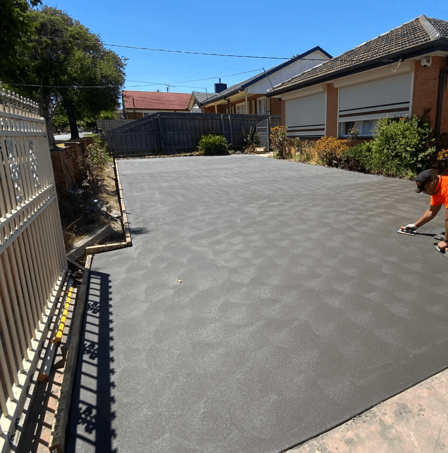 Concreter finishing a freshly poured driveway in Melbourne