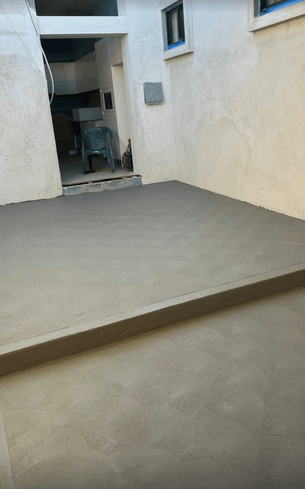 Smooth concrete slab patio finished off a rear entry