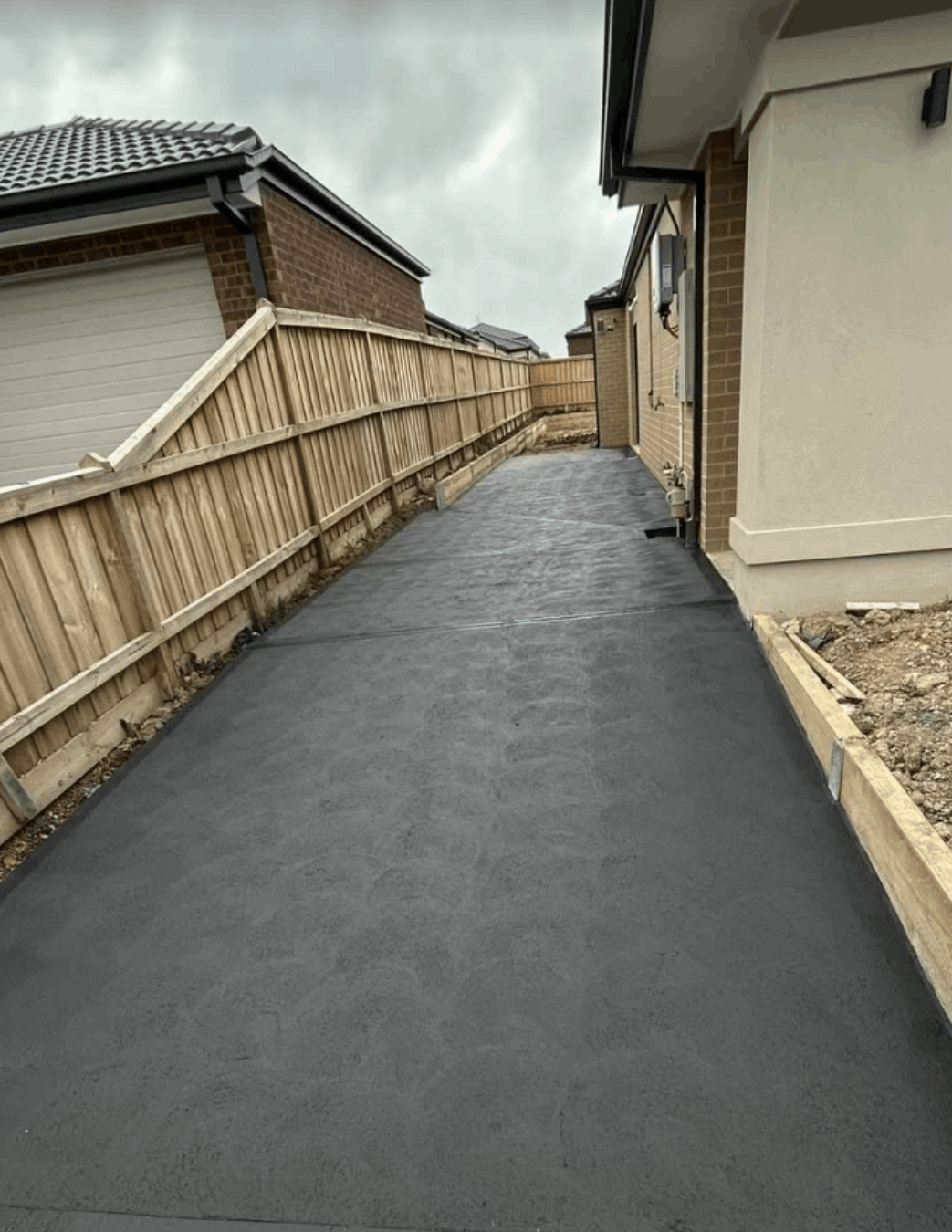 Charcoal concrete pathway between two Melbourne homes
